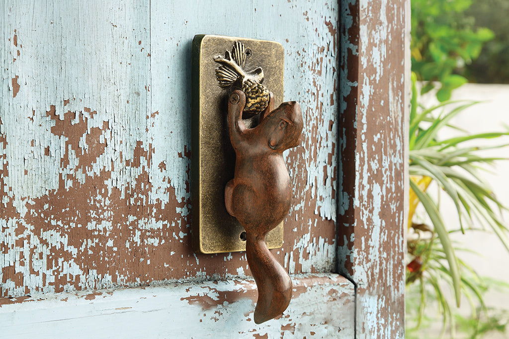 cast metal squirrel with acorn on rectangle plate door knocker