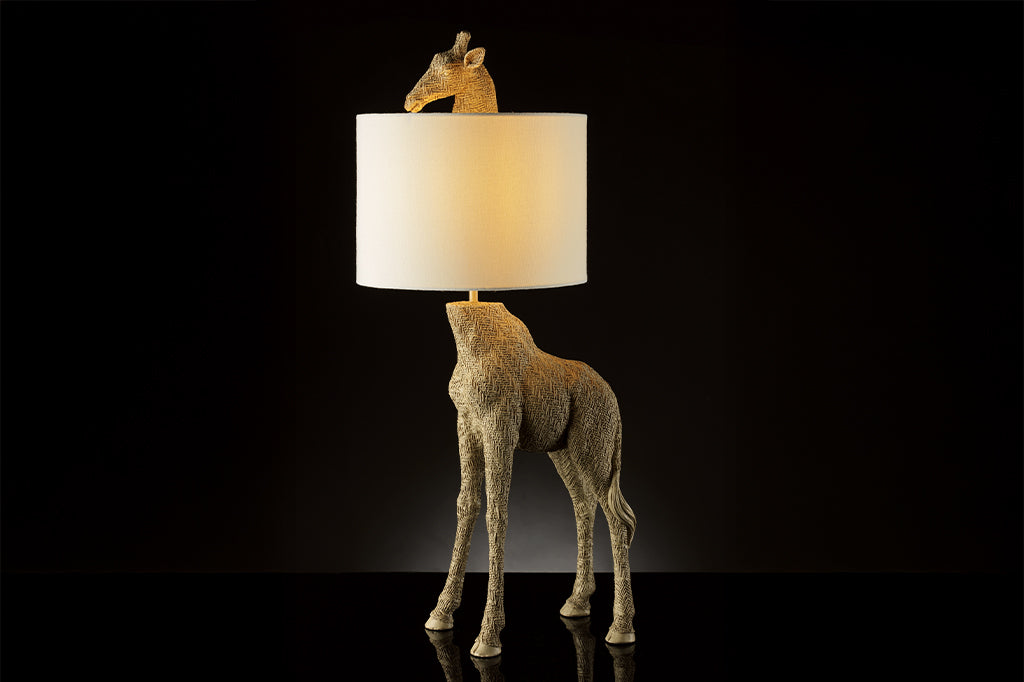 textured golden giraffe lamp with head poking out from top of white fabric shade face left