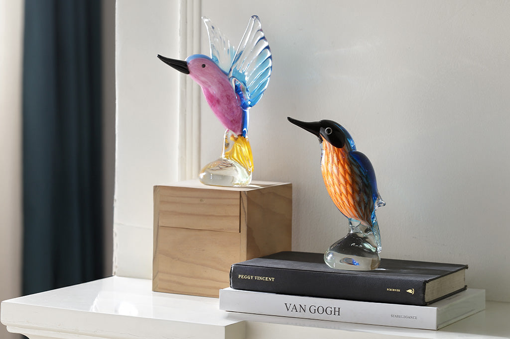 two glass hummingbirds on a desk display