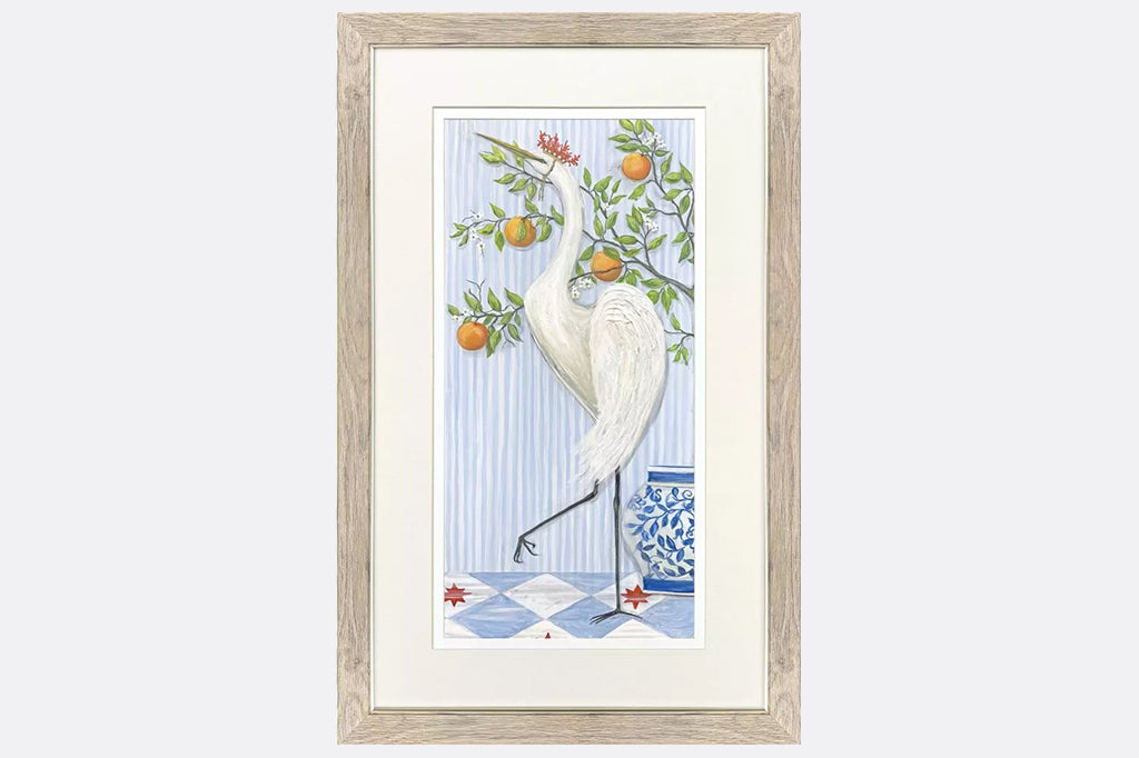 Framed artwork of cranes wearing crowns made of coral next to fruit trees.