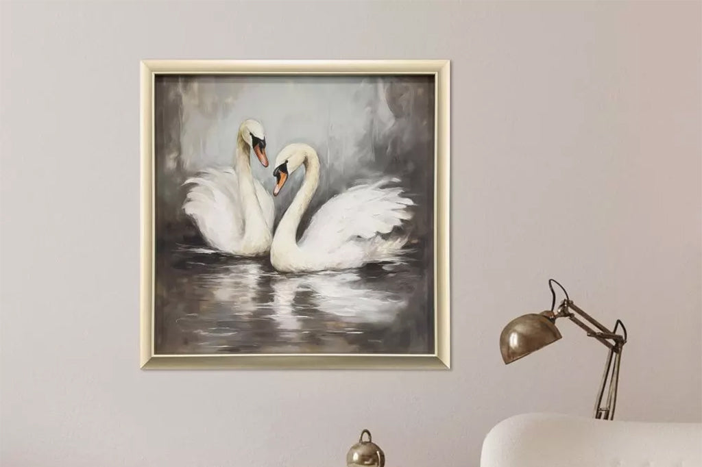 Framed artwork of two swans in water.