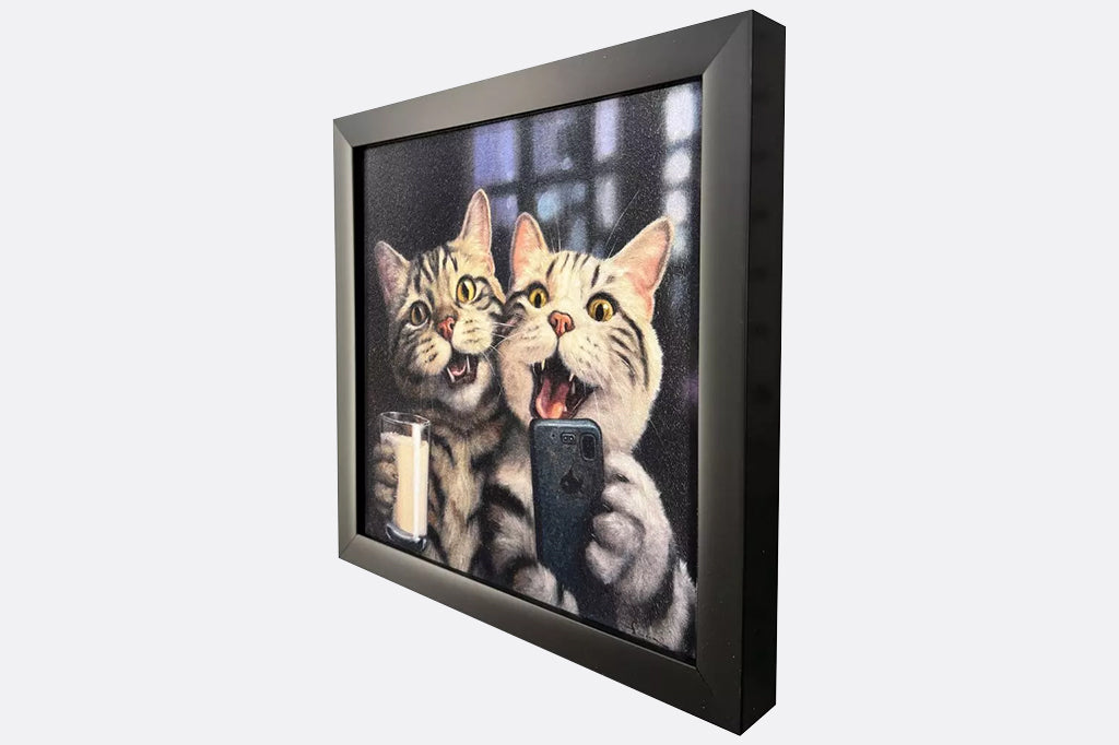 A framed artwork of two cats at a happy hour drinking milk and taking a selfie.