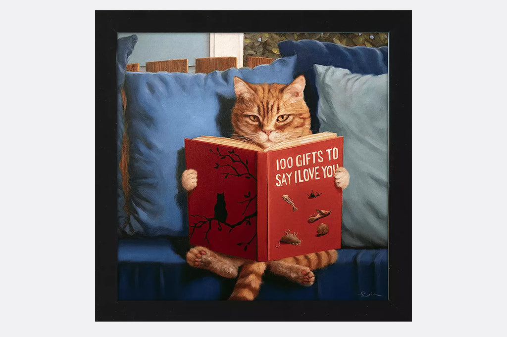 Cat sitting on a couch reading a book titled '100 Gifts to Say I Love You'.