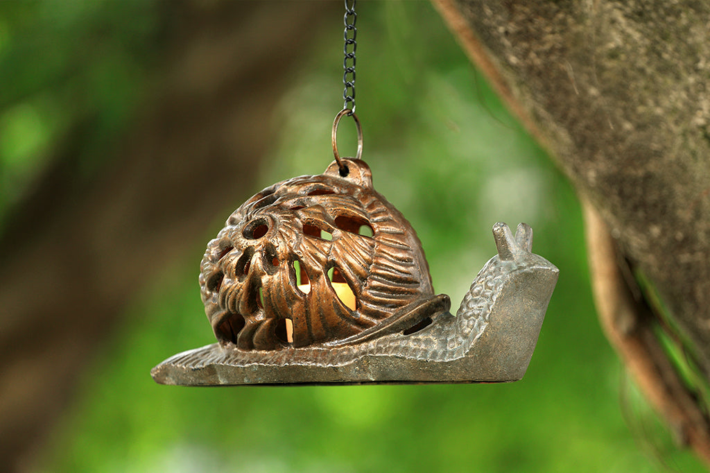 hanging from a chain under tree is one Garden Snail Lantern