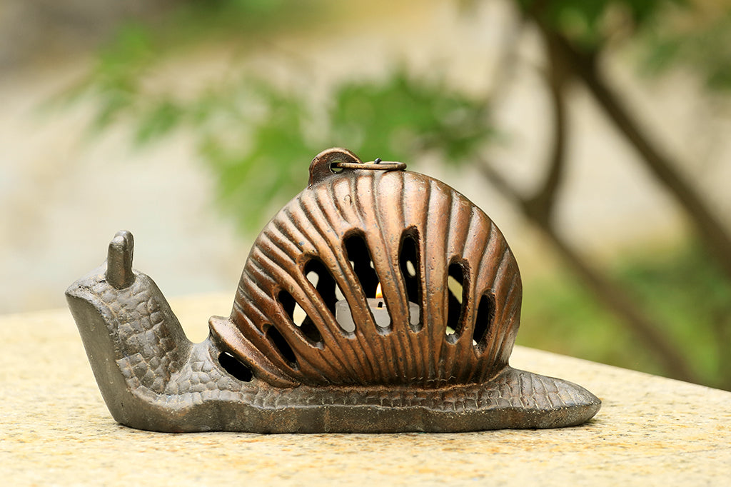 single Garden Snail Lanterns shown on outdoor table near tree