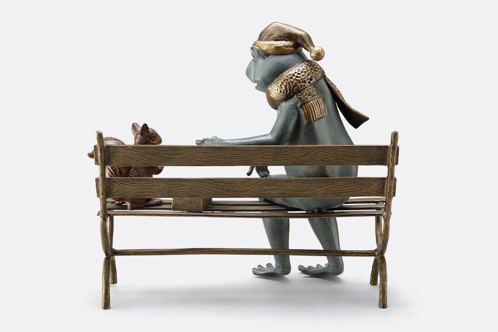 Frog and squirrel statue gifting an acorn on a bench