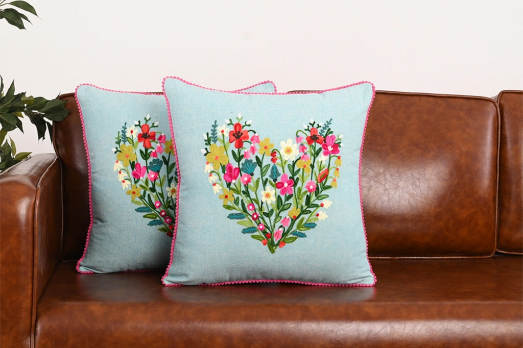 Floral heart design on decorative pillows on a brown leather couch