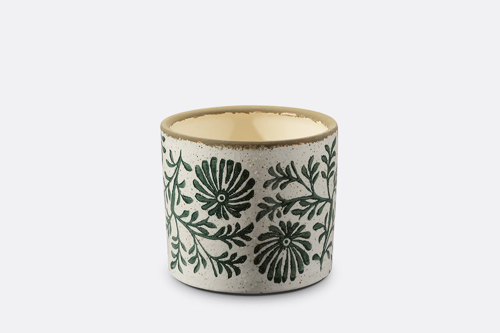 Ceramic pot with green floral patterns on a white background