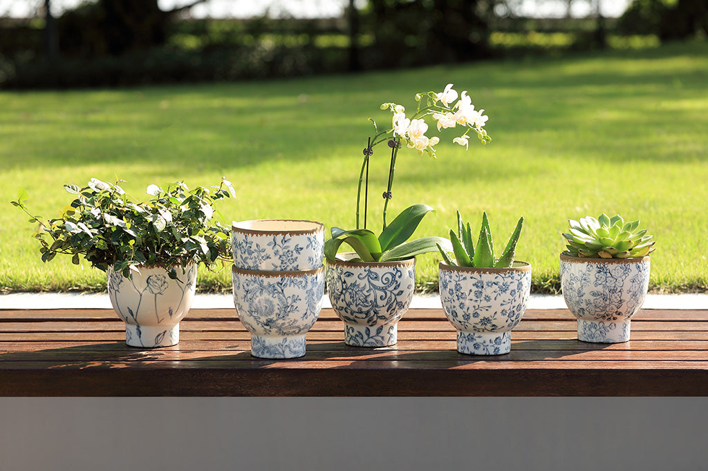 White and blue ceramic pots with flowers and vine designs.