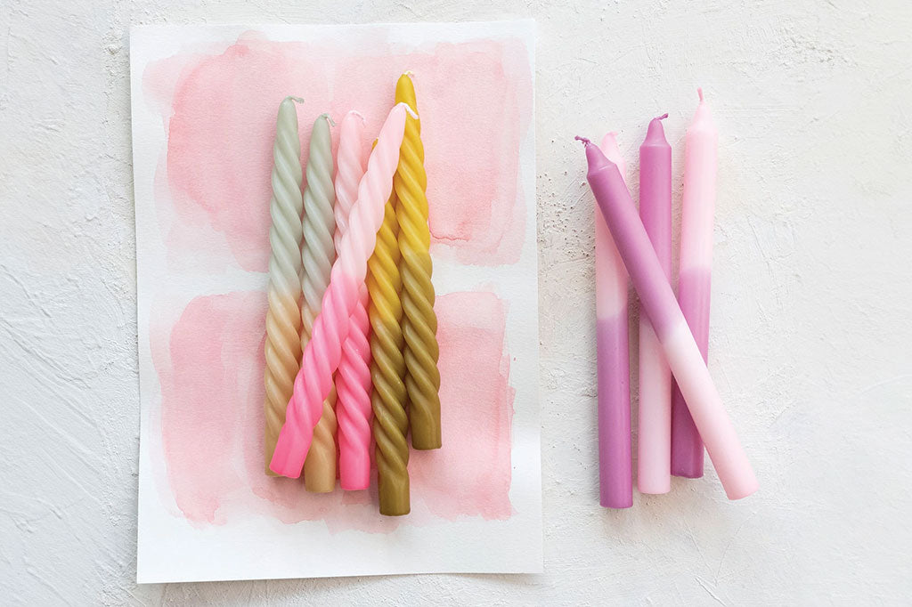 twisted two-tone pink taper candle staged with yellow and cream candles