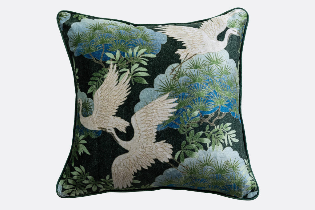 soaring white cranes with foliage on dark backing pillow, green blue velvet backing