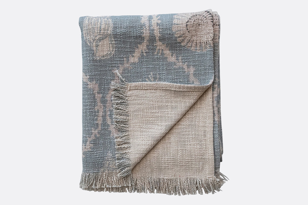 cream colored back side of blue sea shell blanket