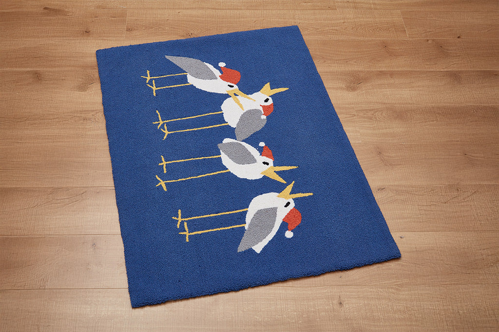 Blue rug with bird design on a wooden floor