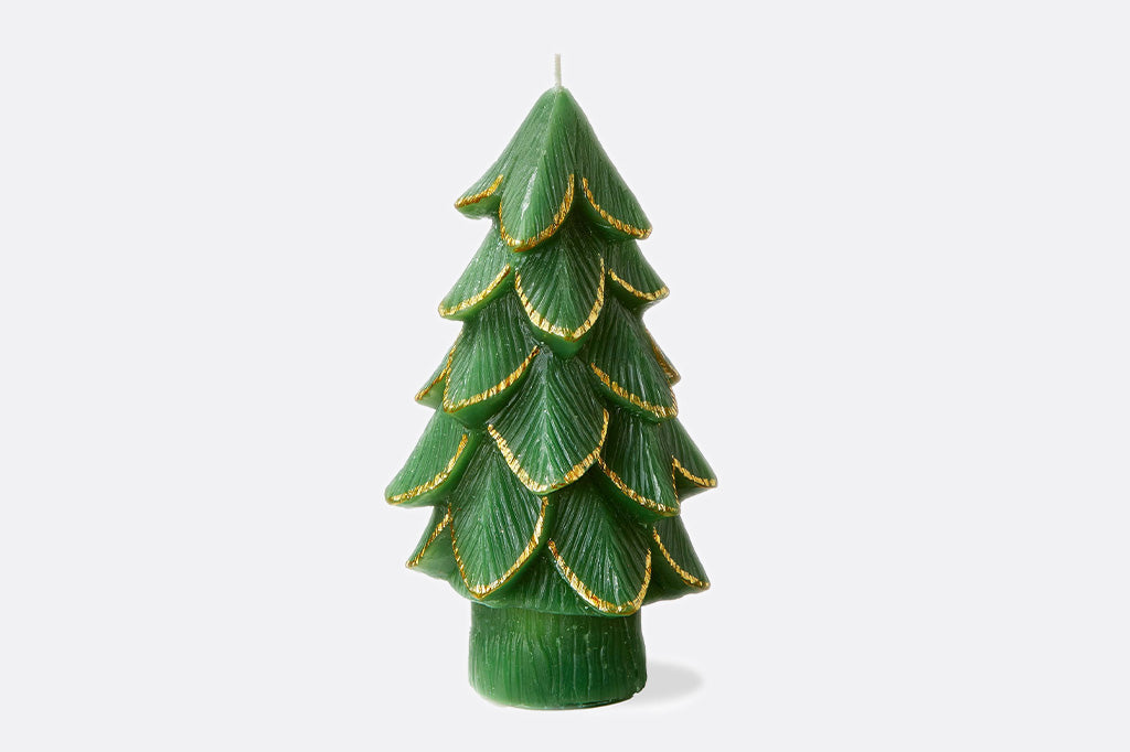 Green candle shaped like a Christmas tree with gold accents on a white background