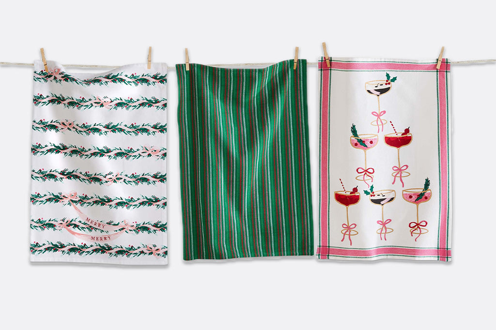 Three patterned towels hanging on a line against a white background