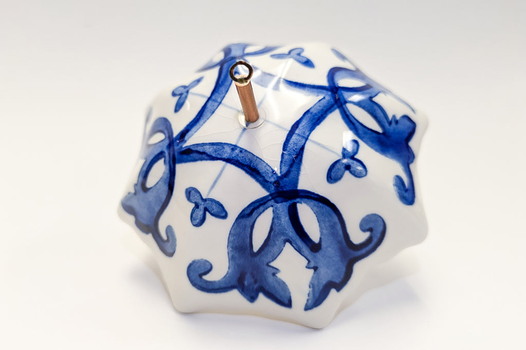 Decorative ceramic umbrella ornament with blue patterns on a white