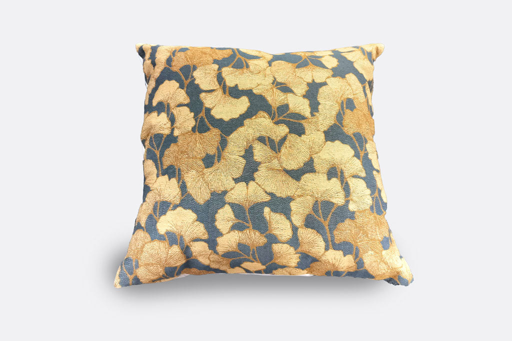Decorative pillow with golden ginkgo leaf pattern on a slate blue background