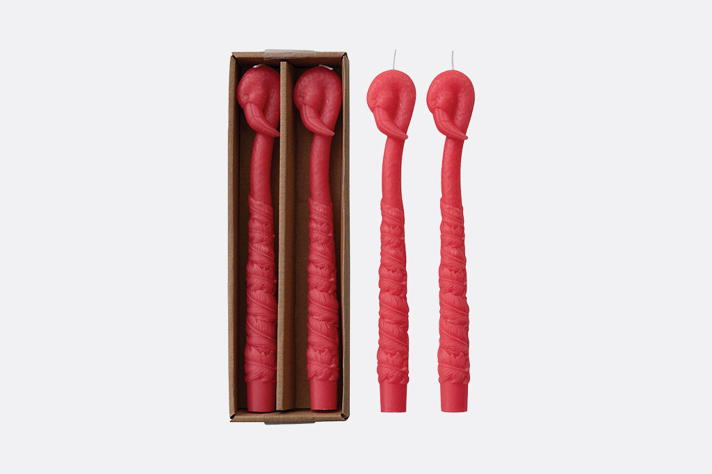 A pack of 4 taper candles shaped like flamingos.