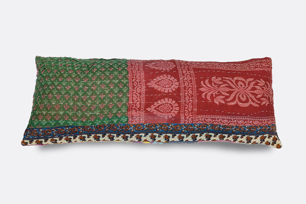 A patchwork pillow inscribed with the phrase "Sleeps with dogs."