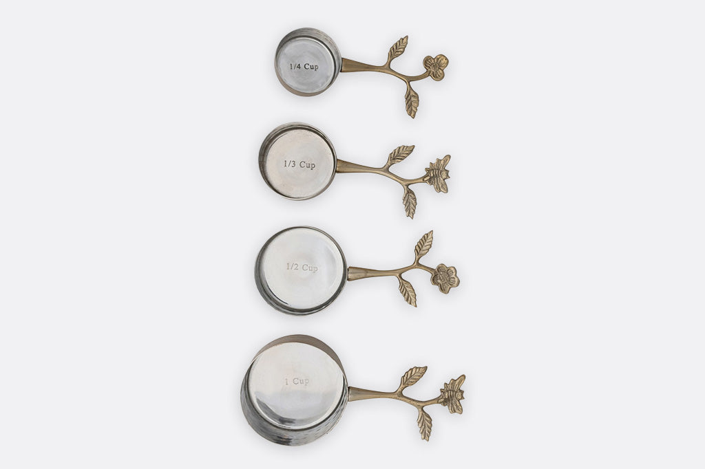 A set of four golden colored measuring cups.