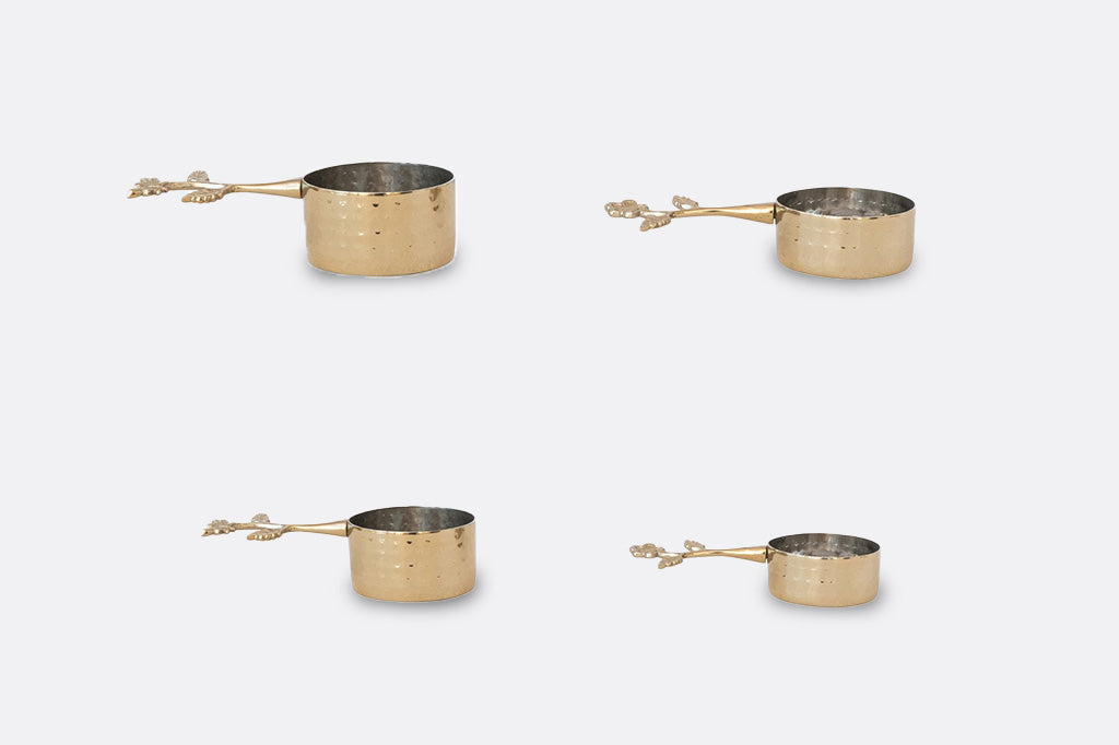 A set of four golden colored measuring cups.