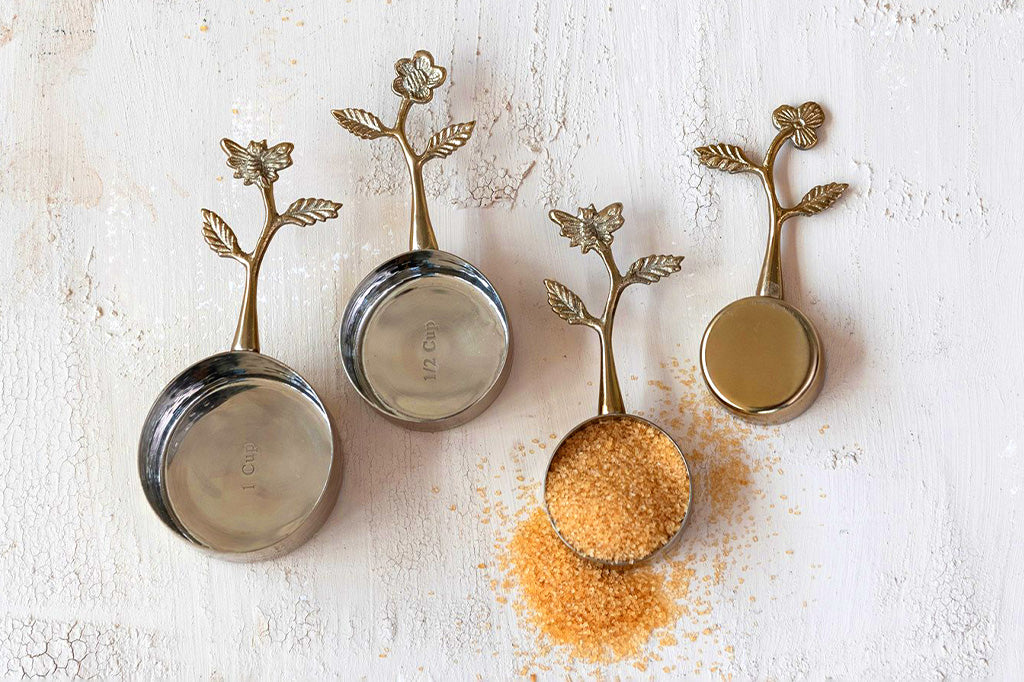 A set of four golden colored measuring cups.