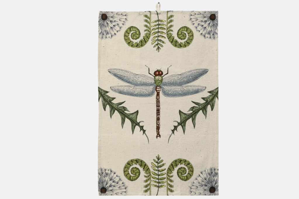 Tea towel with a dragonfly and fern design on a beige background