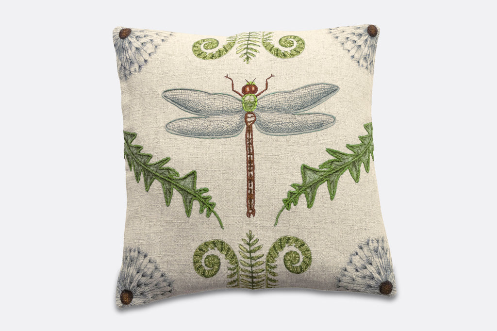 Decorative pillow with a dragonfly and leaf design on a beige background