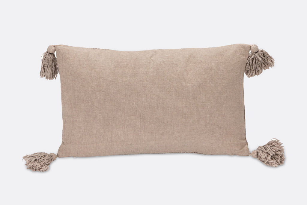 A pillow with illustrations of flowers, dandelions, and dragonflies.