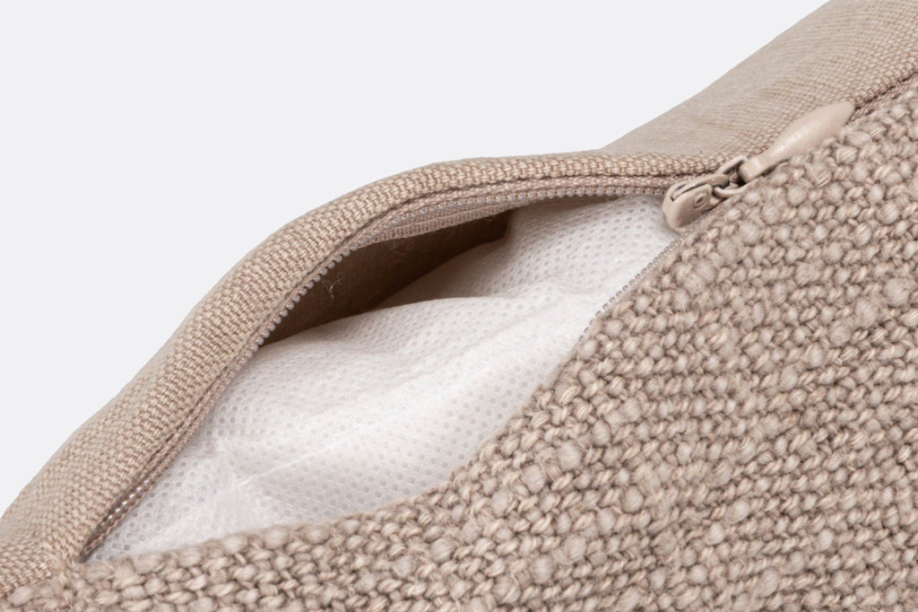 Close-up of a textured fabric with a zipper, showing the interior lining.
