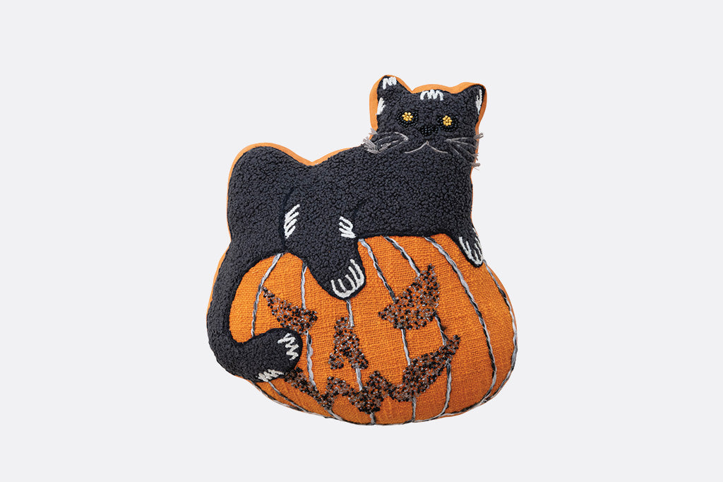 Decorative pillow with a black cat on a pumpkin design on a white background
