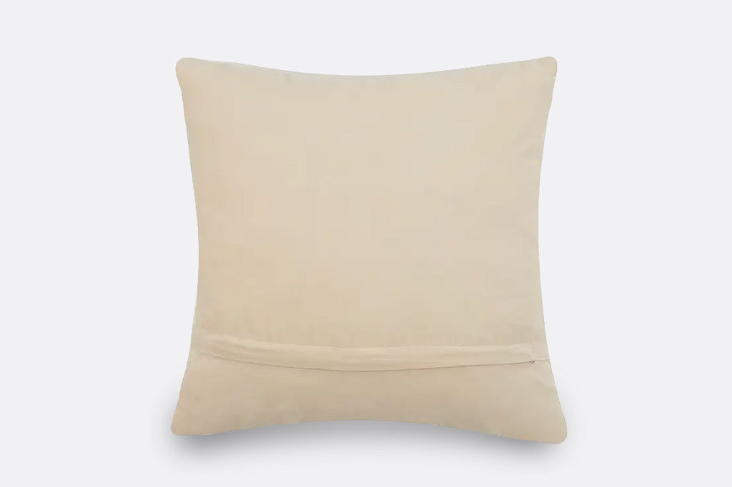 A square beige throw pillow with a smooth fabric texture and a horizontal stitched seam near the bottom, shown against a plain light gray background.