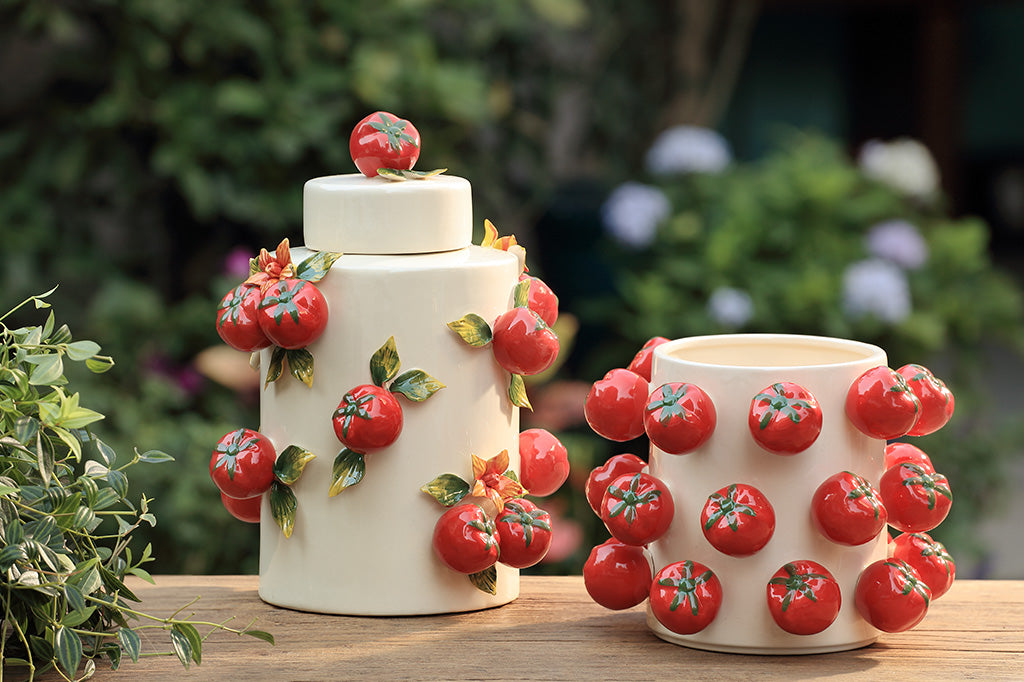 A jar with a tomato design and a matching vase