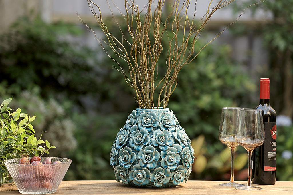 Decorative teal vase with floral patterns