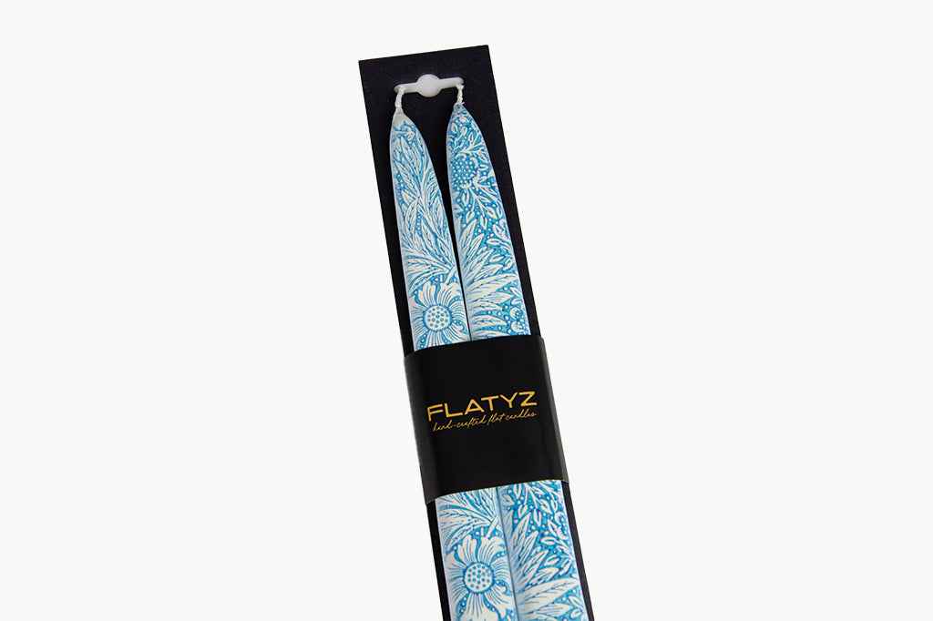 Flatyz product packaging with a blue floral patterned taper candle pair inside