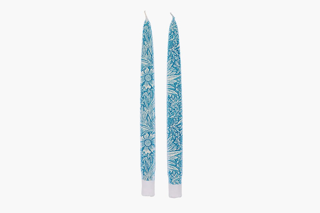 Pair of blue floral-patterned taper candles on a white background