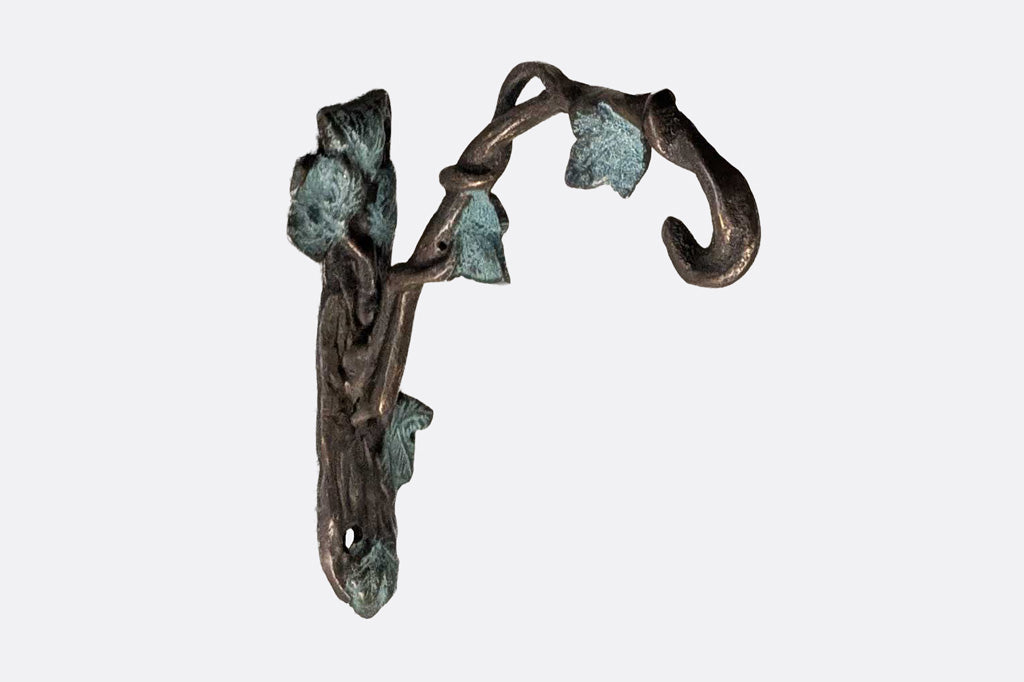 closeup detail of wall hook for hanging garden bell with leaf sculpting in verdi finish