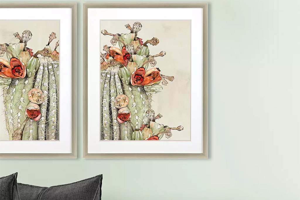 framed cactus and blooms painting on wall above couch