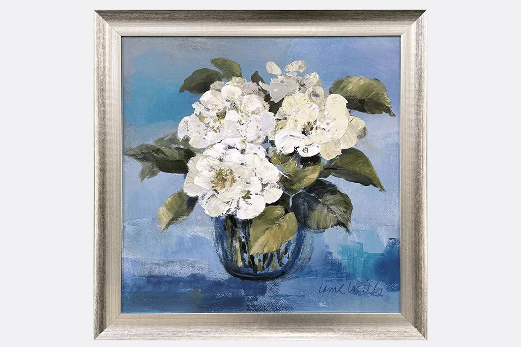 framed print of three white flowers in a blue vase on a blue background
