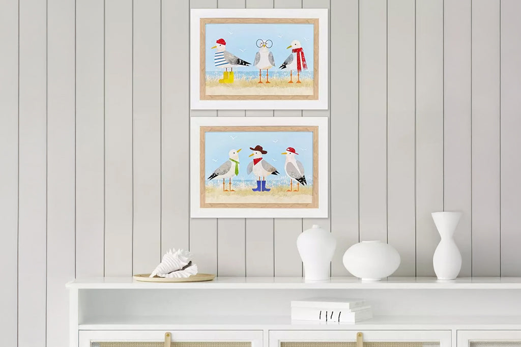 Set of two framed prints of quirky dressed up seagulls on beach, seagulls dressed in cowboy hat and boots on wall