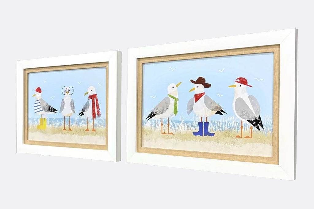 side view of Set of two framed prints of quirky dressed up seagulls on beach, seagulls dressed in cowboy hat and boots. In white and light wood frame
