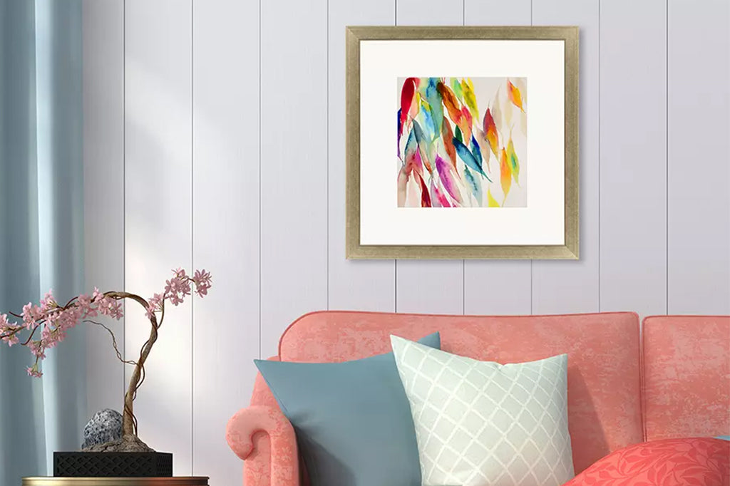 A cascade of colorful leaves falling in soft gold frame mounted above couch in Livingroom scene