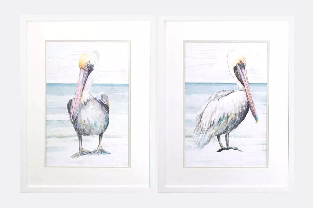 A set of two pelicans walk along the beach. Prints are double matted with a white top mat and framed in a modern flat white moulding.