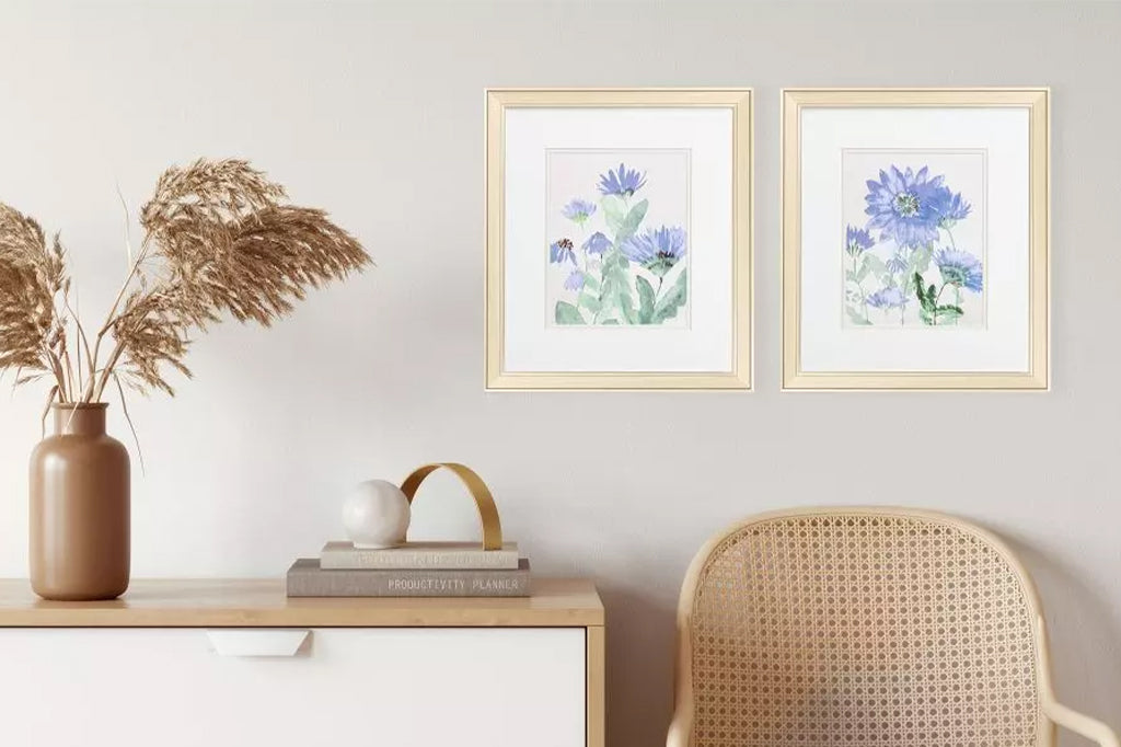 A set of two floral images that are accentuated with double matting. These pieces are framed under glass and paired with a champagne frame. Mounted on wall
