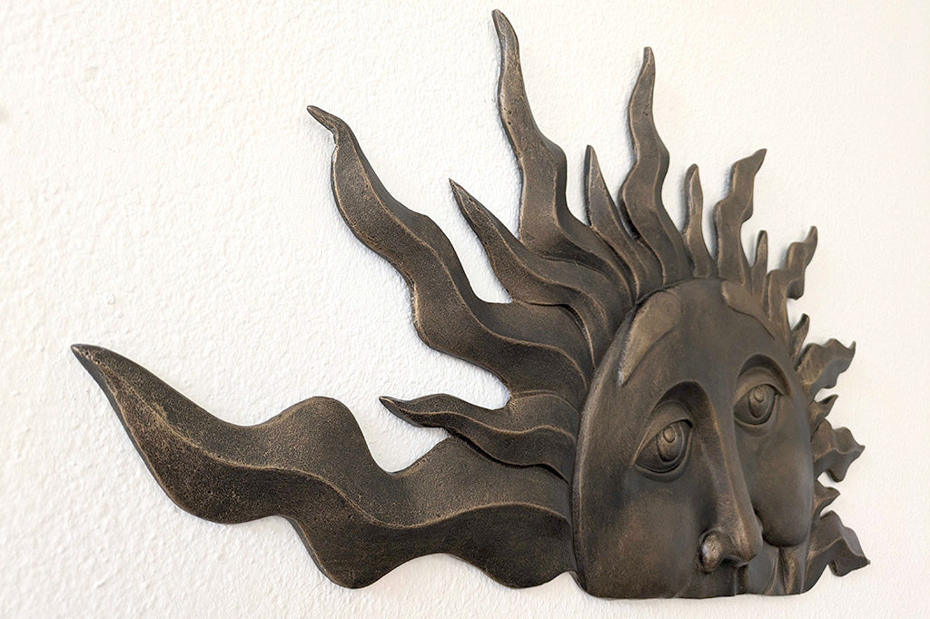 side view to she the 3D sculpted nose and eyes of a setting sun wall plaque