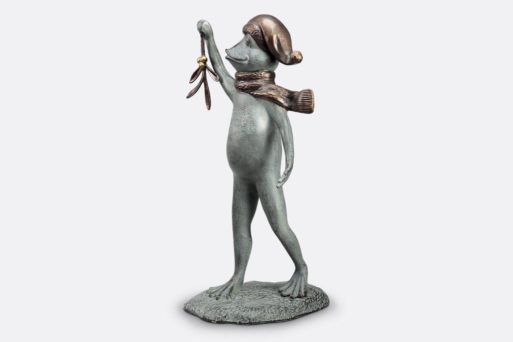 garden sculpture of frog in winter garb holding mistletoe from outstretched webbed hand