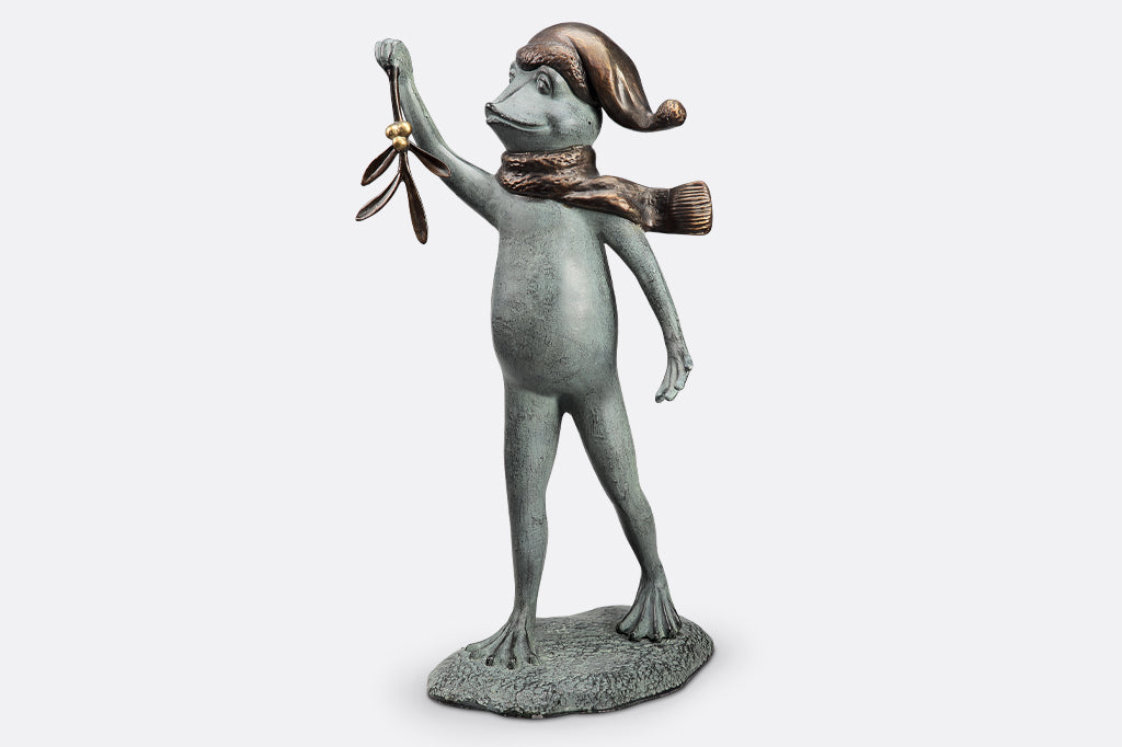 garden sculpture of frog in winter garb holding mistletoe from outstretched webbed hand
