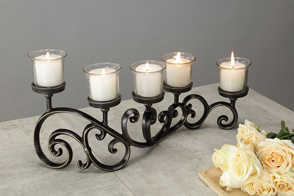 classic scrollwork design on table candelabra that holds 5 candles in glass cups