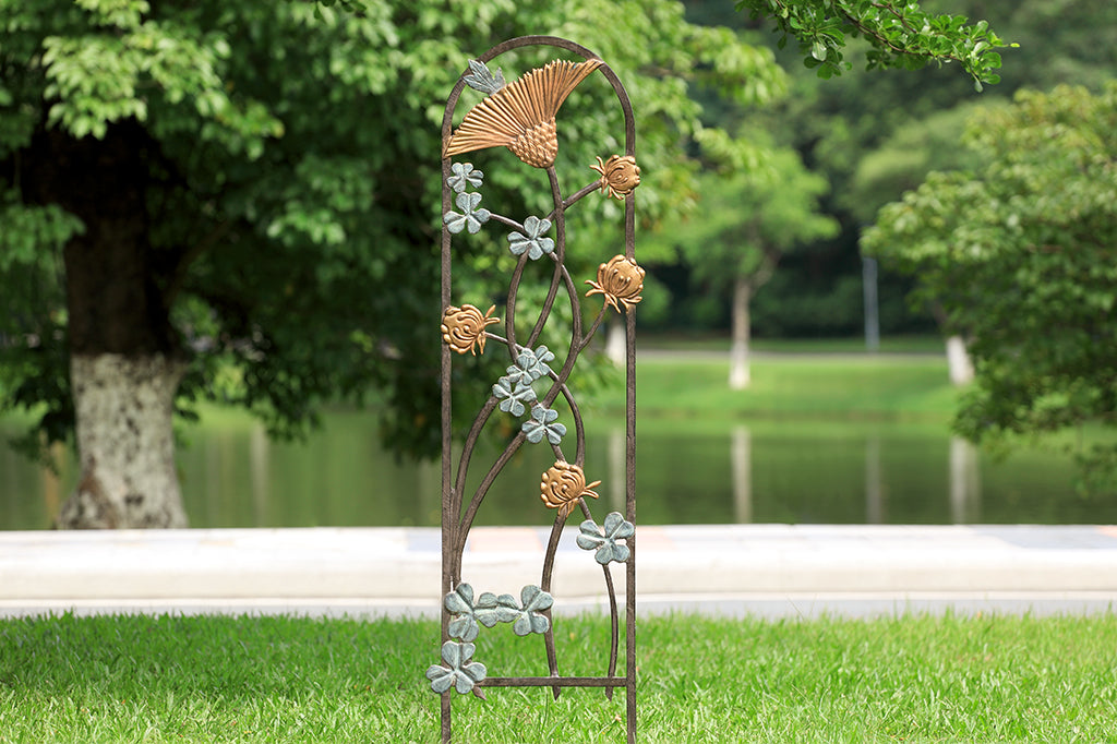 cast metal garden trellis with clover flower and leaf detailing, placed on grass 