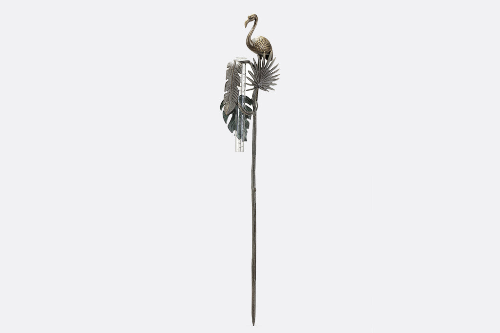 decorative garden rain catcher shows cast metal flamingo, and 3 tropical leaf accents